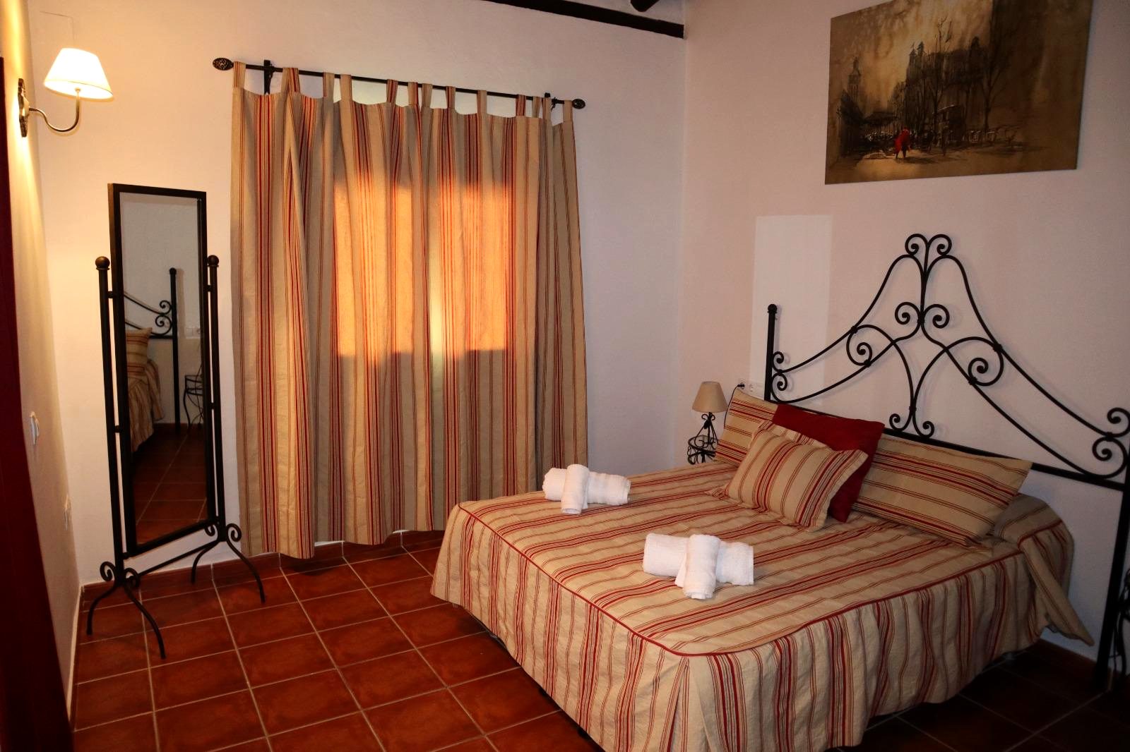 Dormitorio principal con cama de matrimonio y cabecero de forja